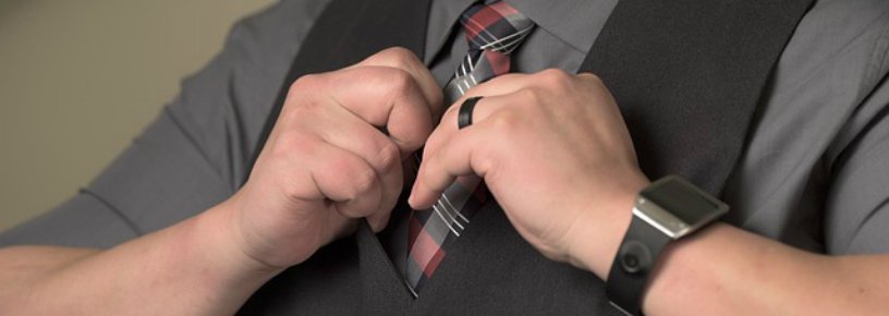 Man adjusting tie