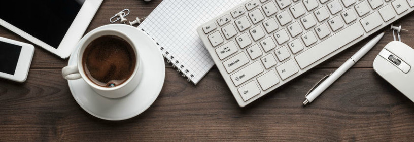 Desk with iphone, ipad, coffee, notebook, and keyboard