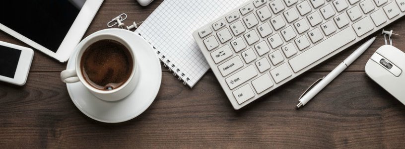 Desk with iphone, ipad, coffee, notebook, and keyboard