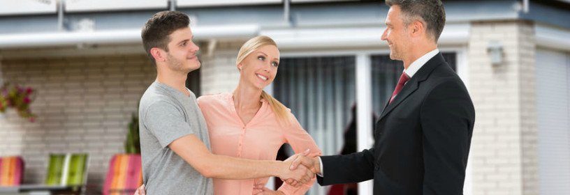 Man and woman shaking agent's hand