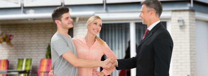 Man and woman shaking agent's hand