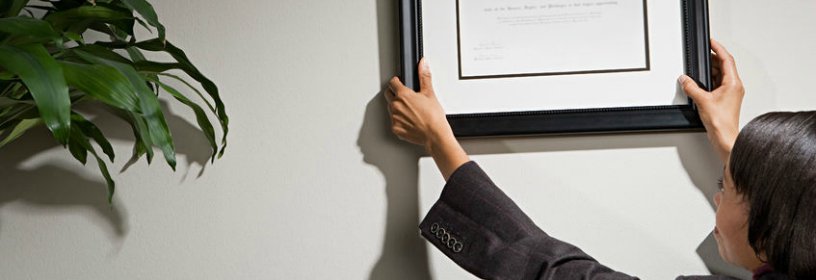 Woman hanging license on wall