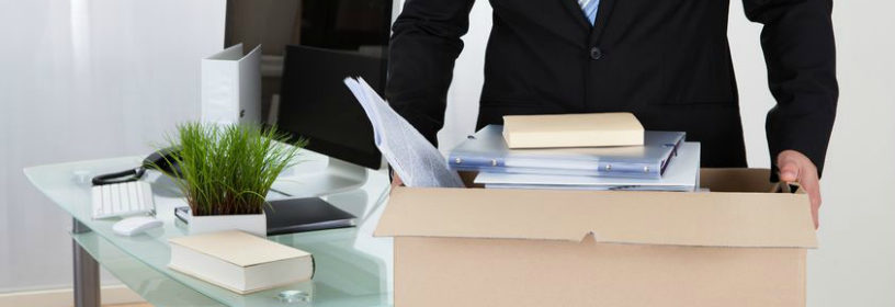 Man carrying box of items from desk