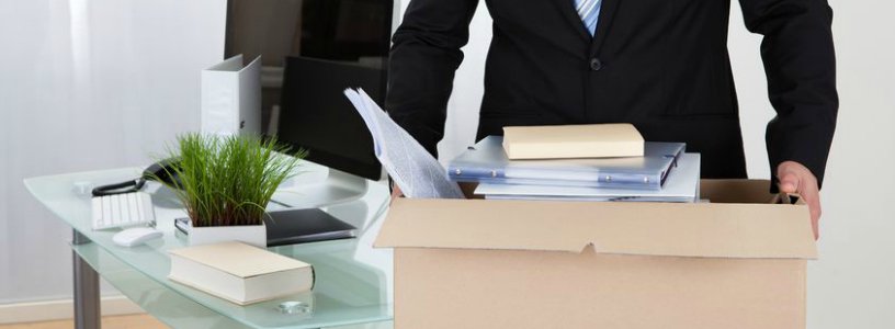 Man carrying box of items from desk