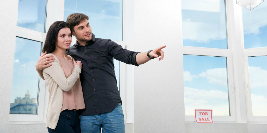 Happy couple pointing at feature of house