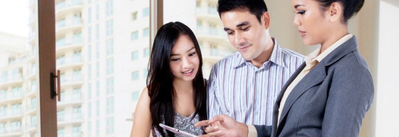 Couple looking at MLS on tablet with Agent