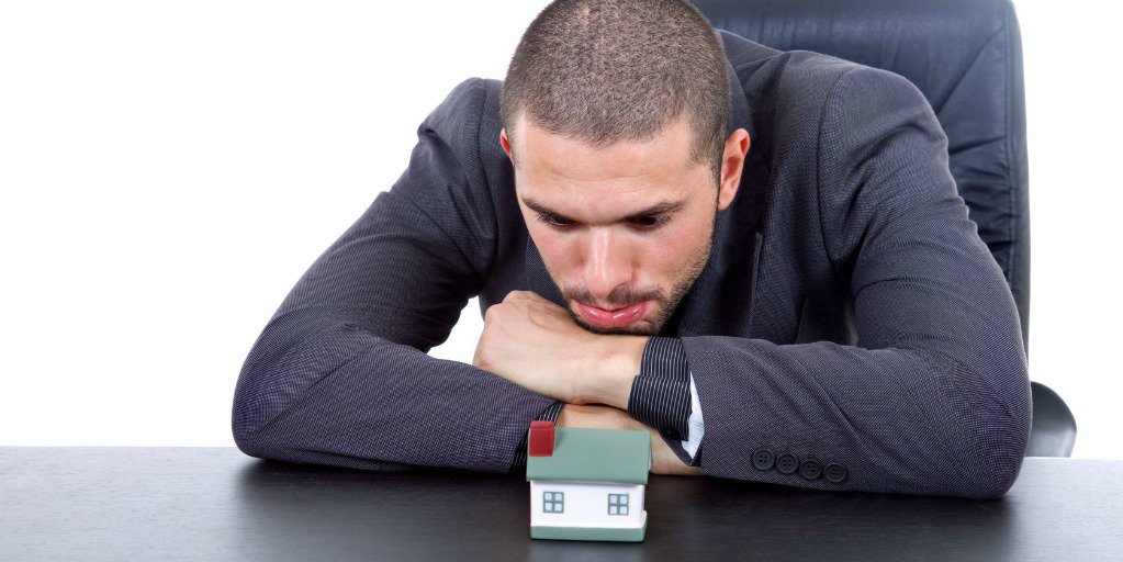 man staring blankly at model house