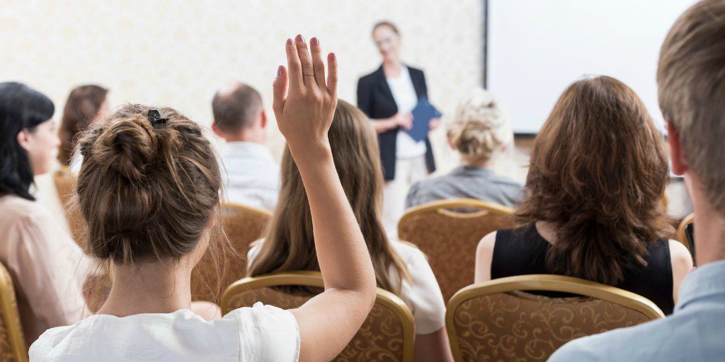 Woman with hand raised asking question