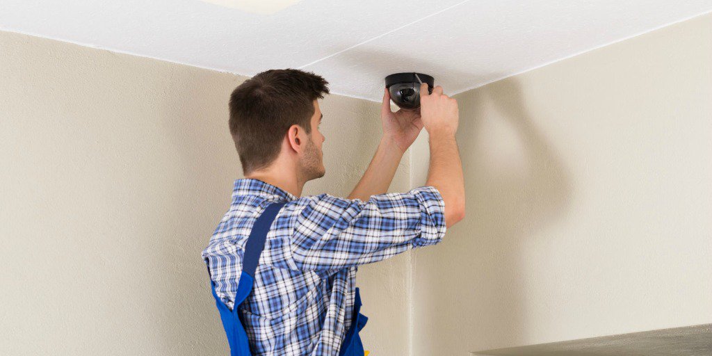 man installing home video surveillance in residence