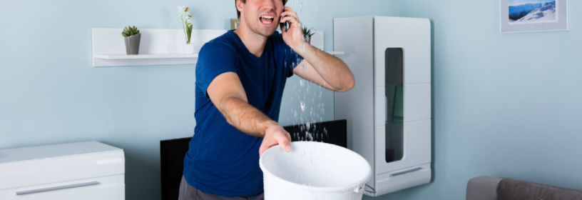 man holding bucket catch water from leaking roof