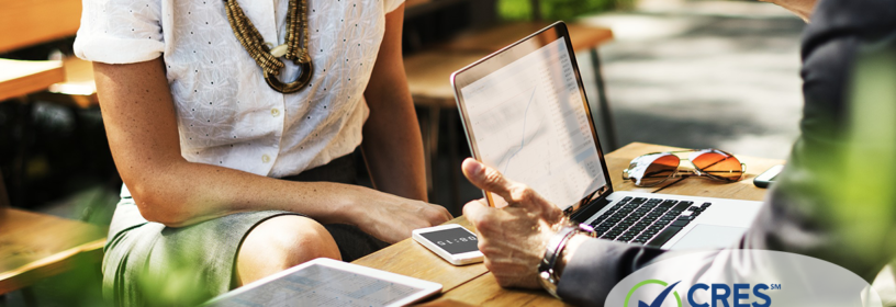 man and woman sitting with laptop discussing contract
