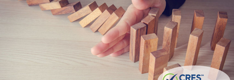 Hand stopping dominos from falling down