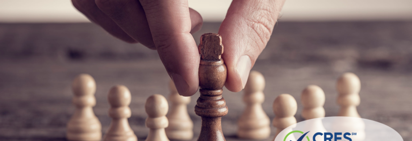 Hand picking up a chess piece