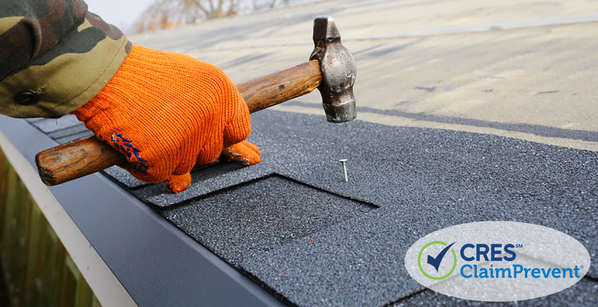 hand hammering nail into roof shingle