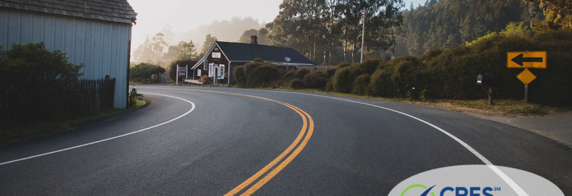 Curve on paved road with house or business on corner of curve