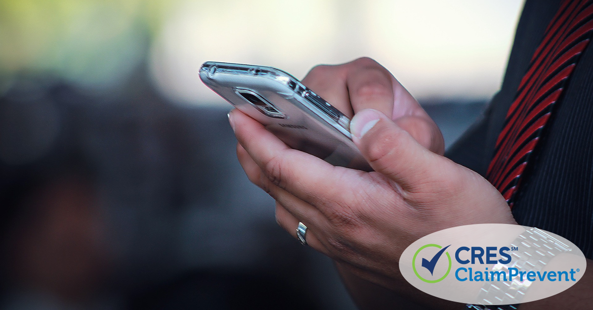 Close up of man in black dress shirt with red striped tie tapping cell phone screen with his finger