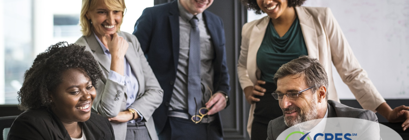 5 culturally diverse team members looking at computer
