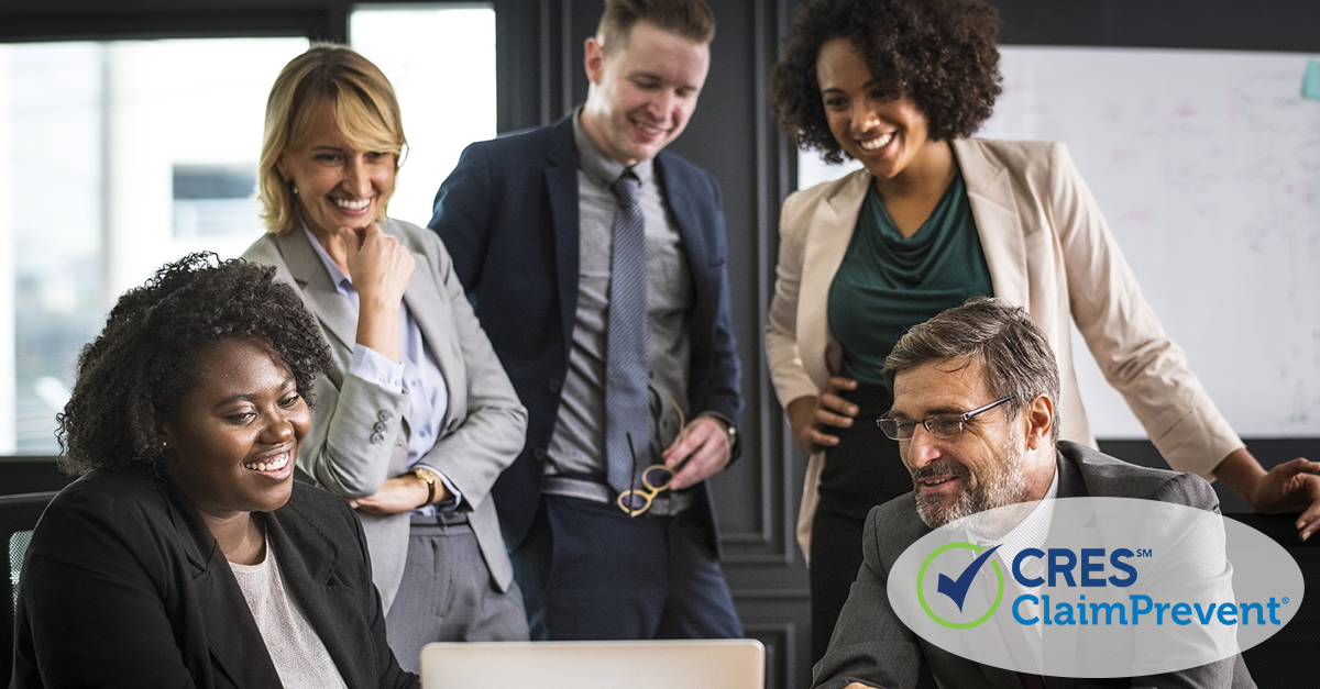 5 culturally diverse team members looking at computer