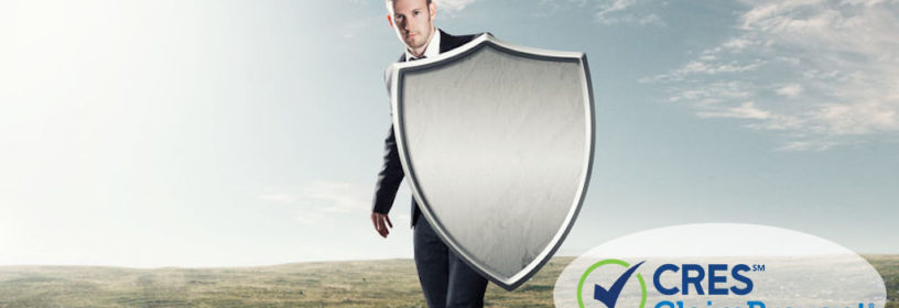 white male in black suit holding an iron shield