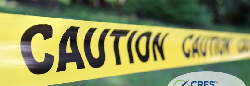 caution tape in front of green grass and trees