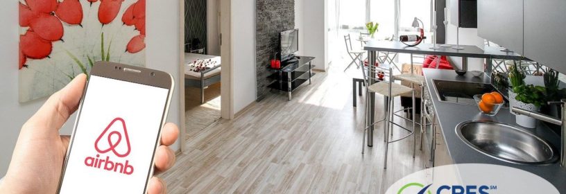 apartment property with person holding smartphone showing airbnb logo