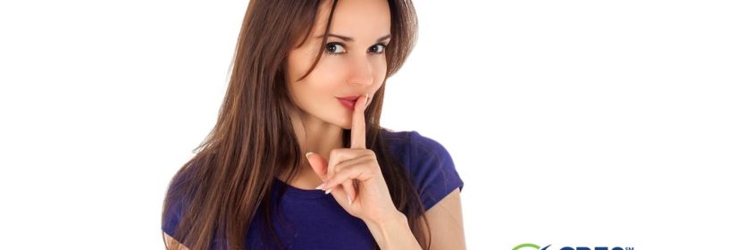 young woman with index finger in front of mouth representing shh