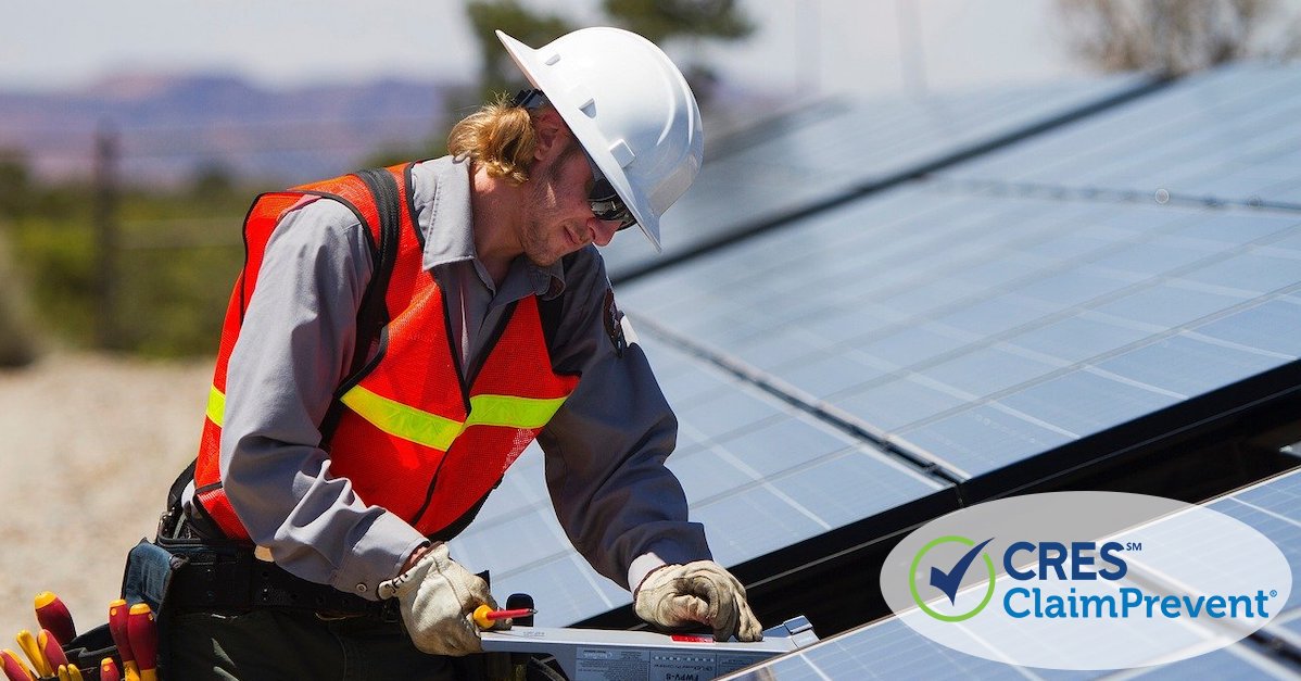 man fixing broken solar panel on house