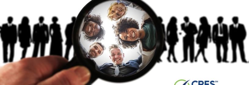magnifying glass highlighting people from a group of shaded figures