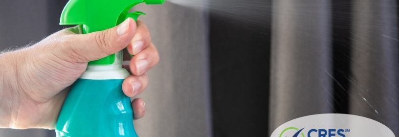 person pulling trigger on disinfectant spray