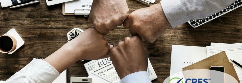 team members bumping fists in an office over a desk