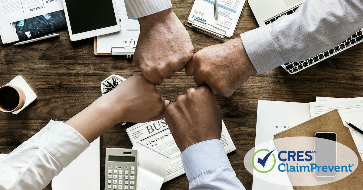 team members bumping fists in an office over a desk