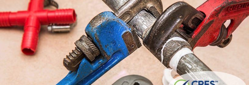 plumbing pipe with red wrench and blue wrench on pipe