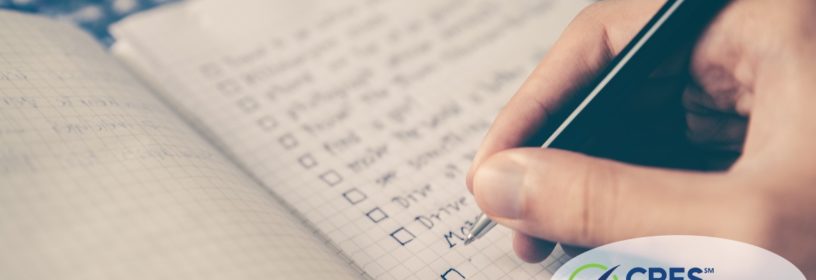 notebook with checklist and person writing with a pen