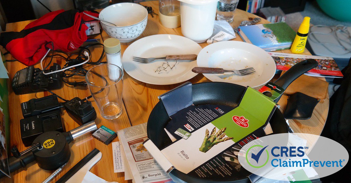 Messy table with Plates, bowls, glasses, and frying pan