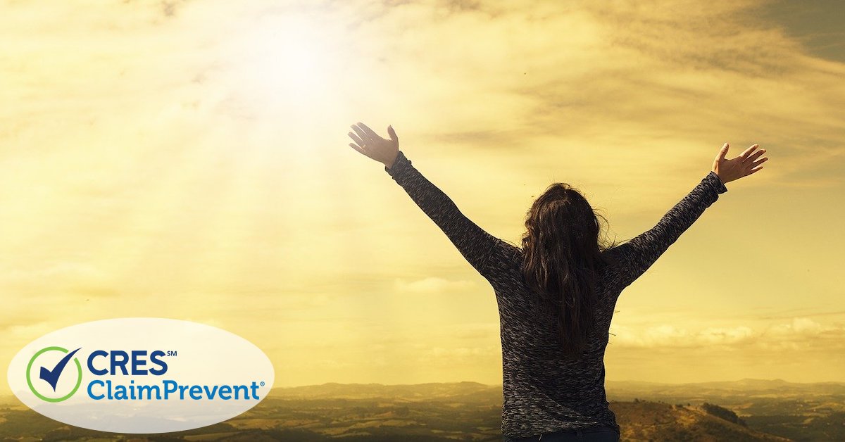 woman holding hands up towards sunrise