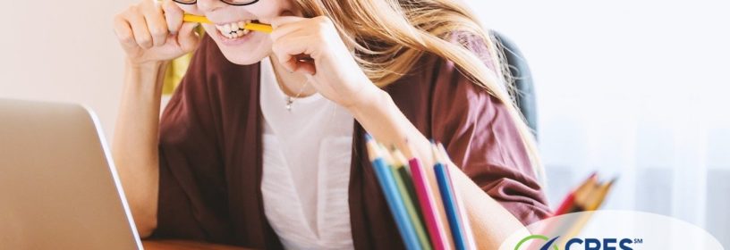 woman looking at laptop screen frustrated with pencil in her mouth