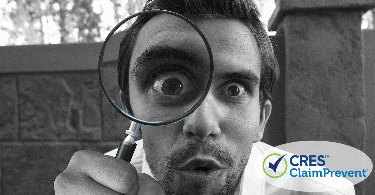 man looking at camera with magnifying glass