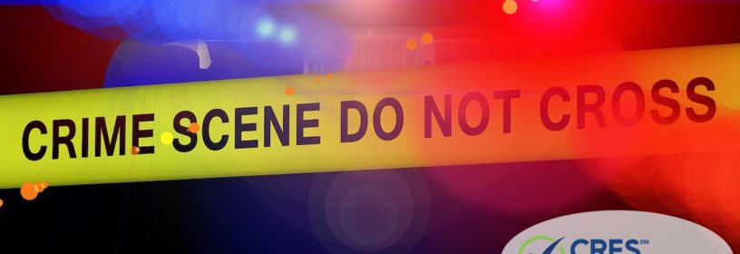 red and blue police lights with crime tape that says "crime scene do not cross"