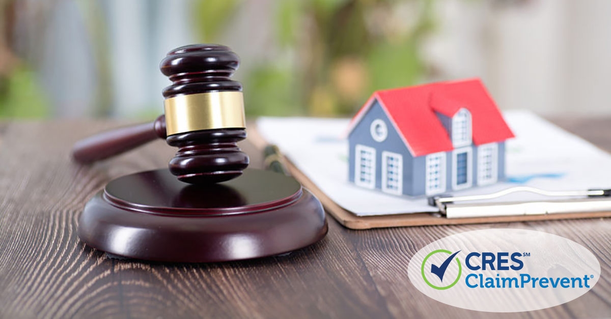 Gavel on a desk with clipboard and toy house