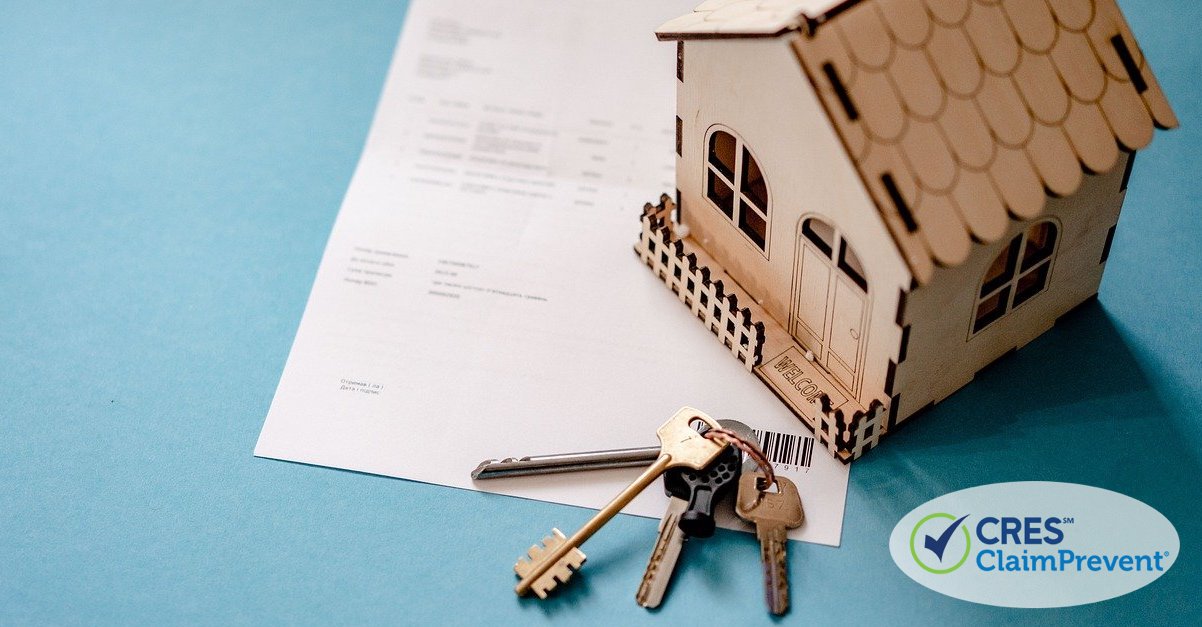 model sized house on document with a set of keys next to it