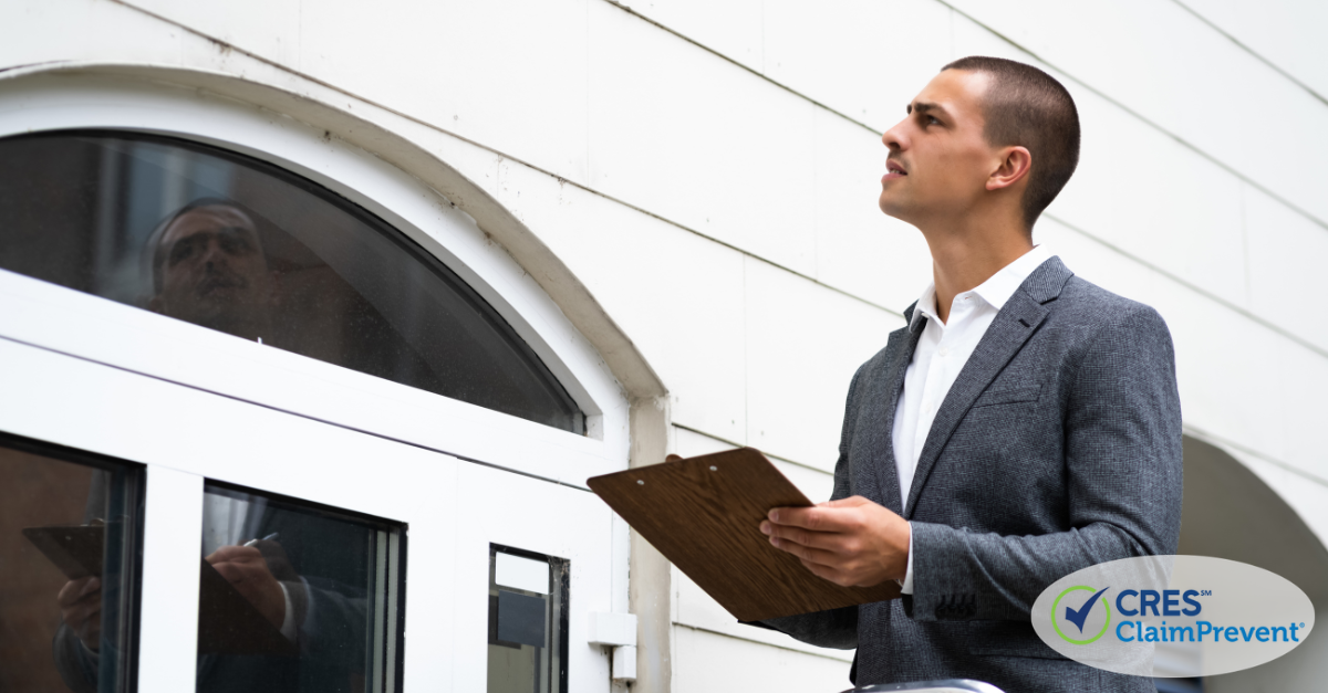 man with clipboard looking at house