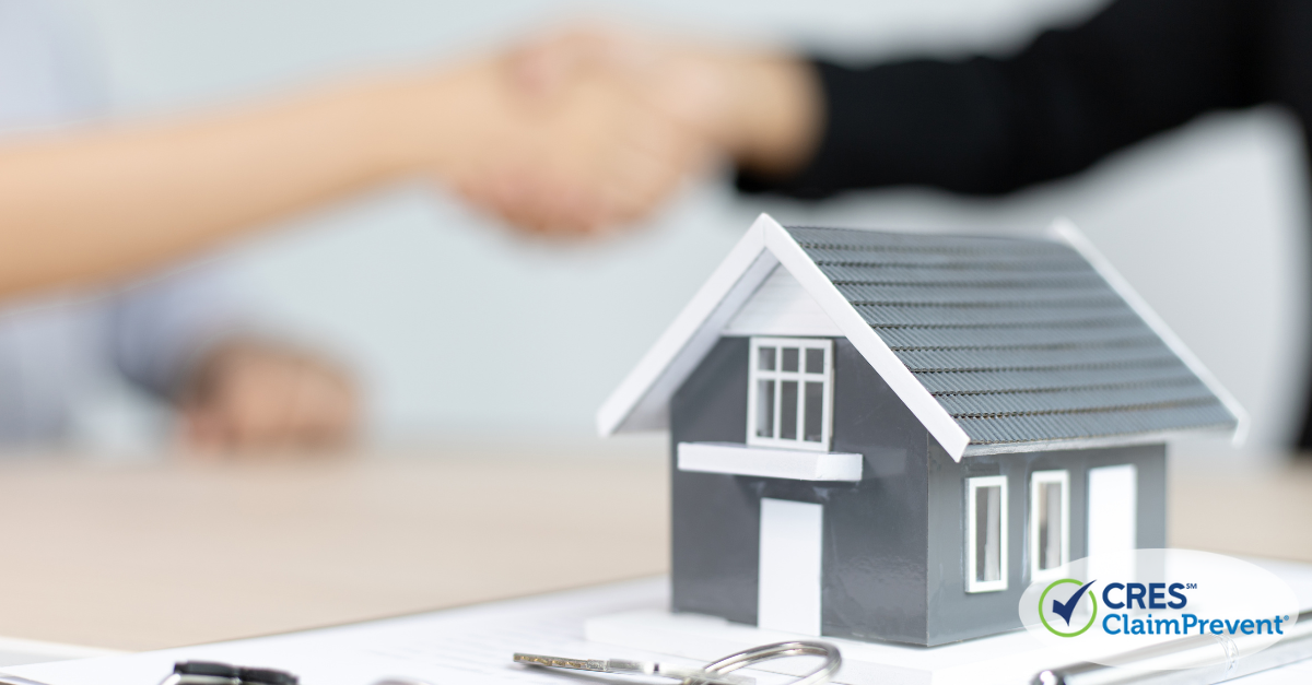 model of a house with people shaking hands behind it