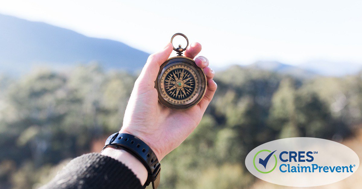 man holding compass in mountains